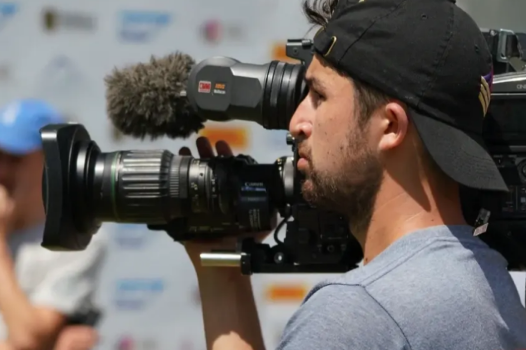 A person holding a camera in front of a crowd
